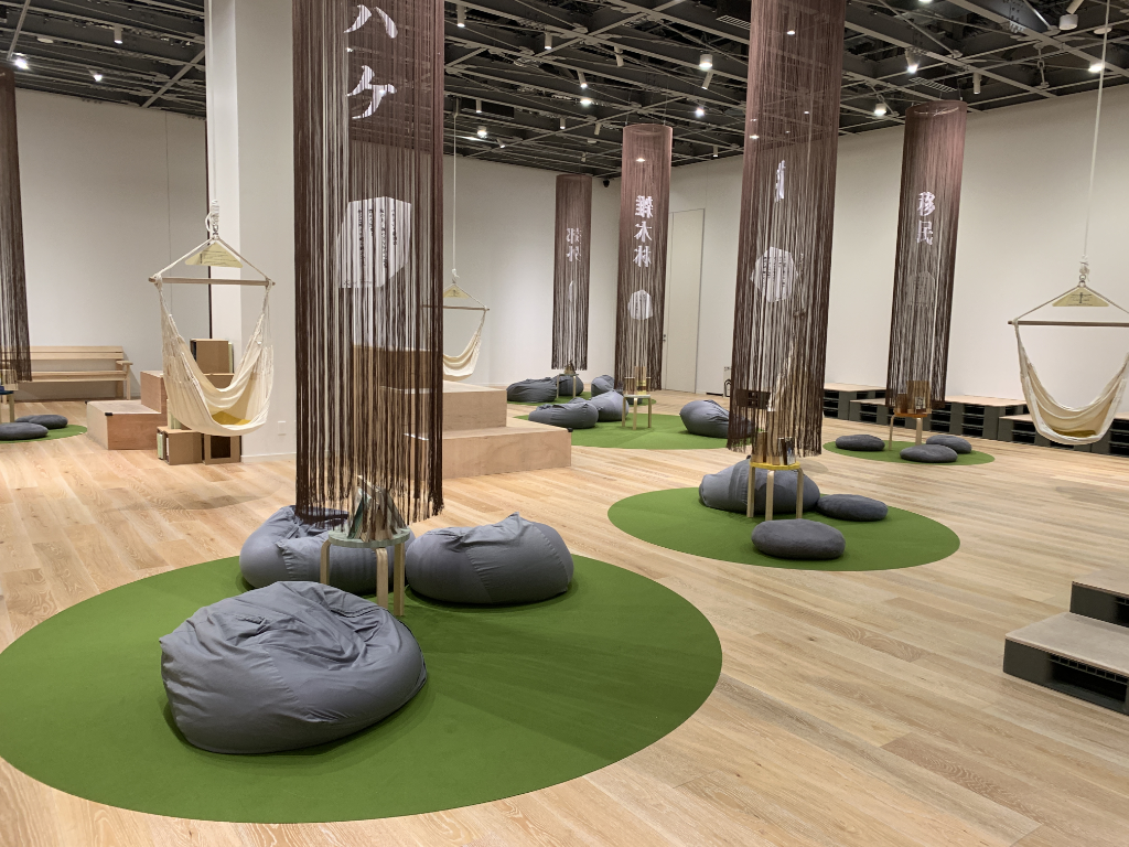 An image of a quiet room with hammocks hanging from the ceiling and soft pillows on the floor for reading.